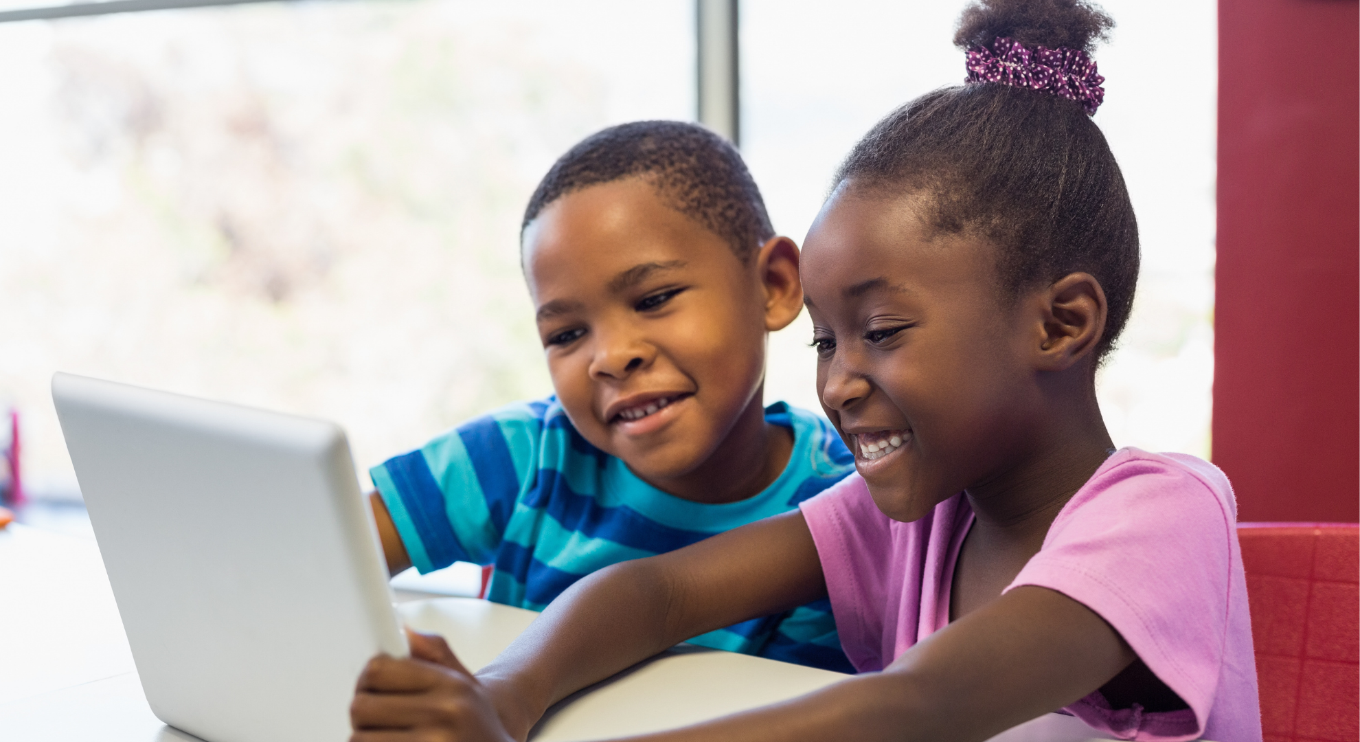 Two children read the tablet