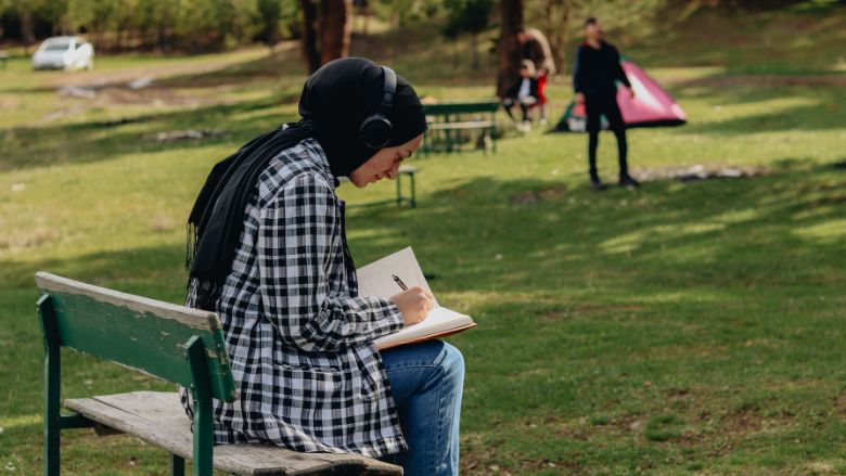 A woman writing on her journal in a parc