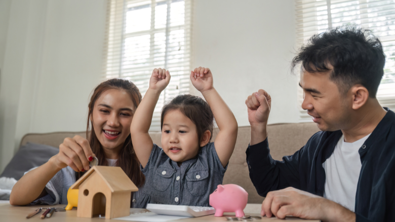 It is the family consisting of parents and a daughter talking about money. In the middle, the little girl raises her arms and is happy.