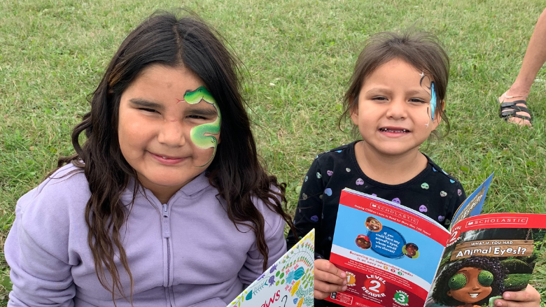 two indigenous children are smiling in a park