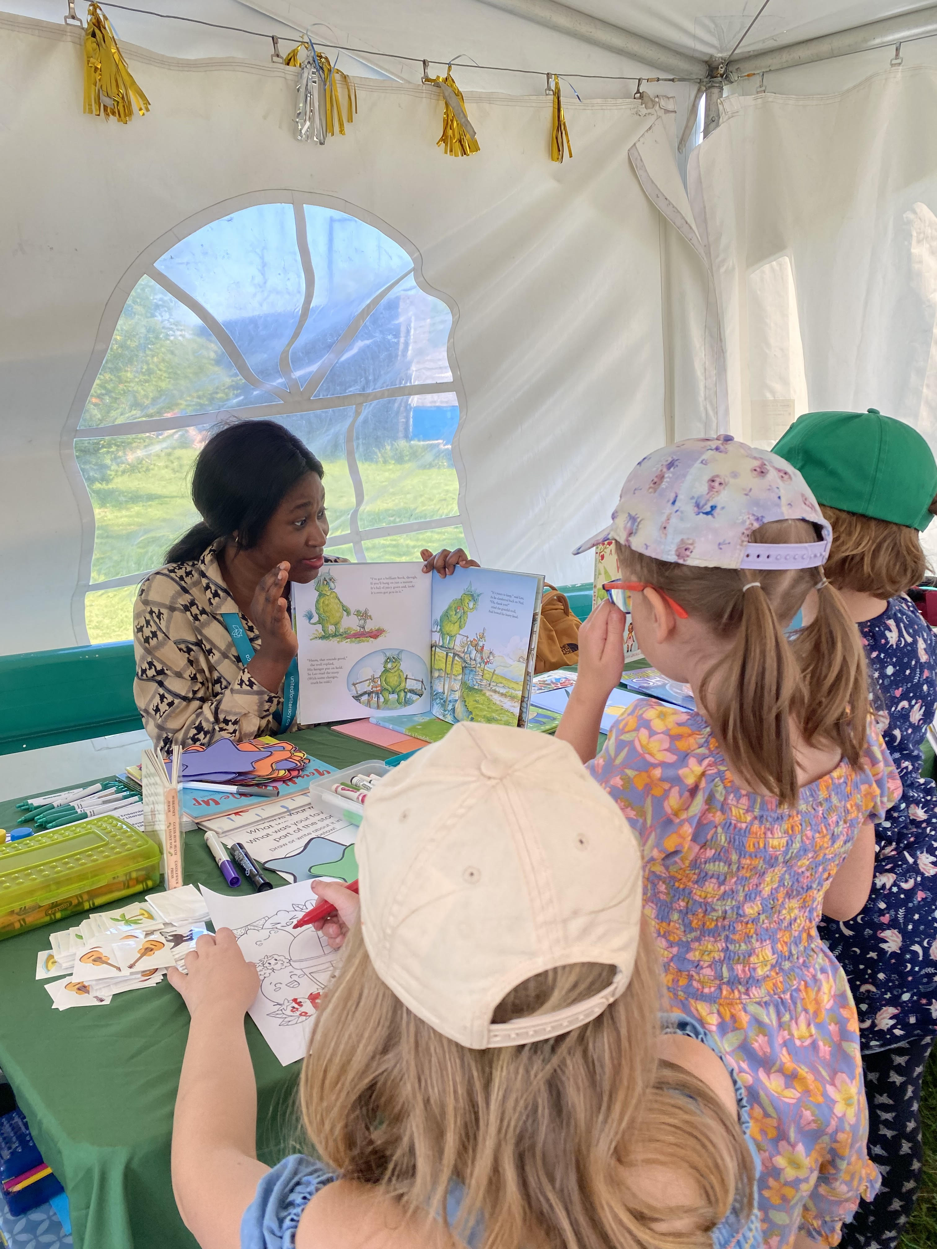 A volunteer reading a book to children