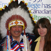 A woman with long hair stands next to Chief Dan Beardy